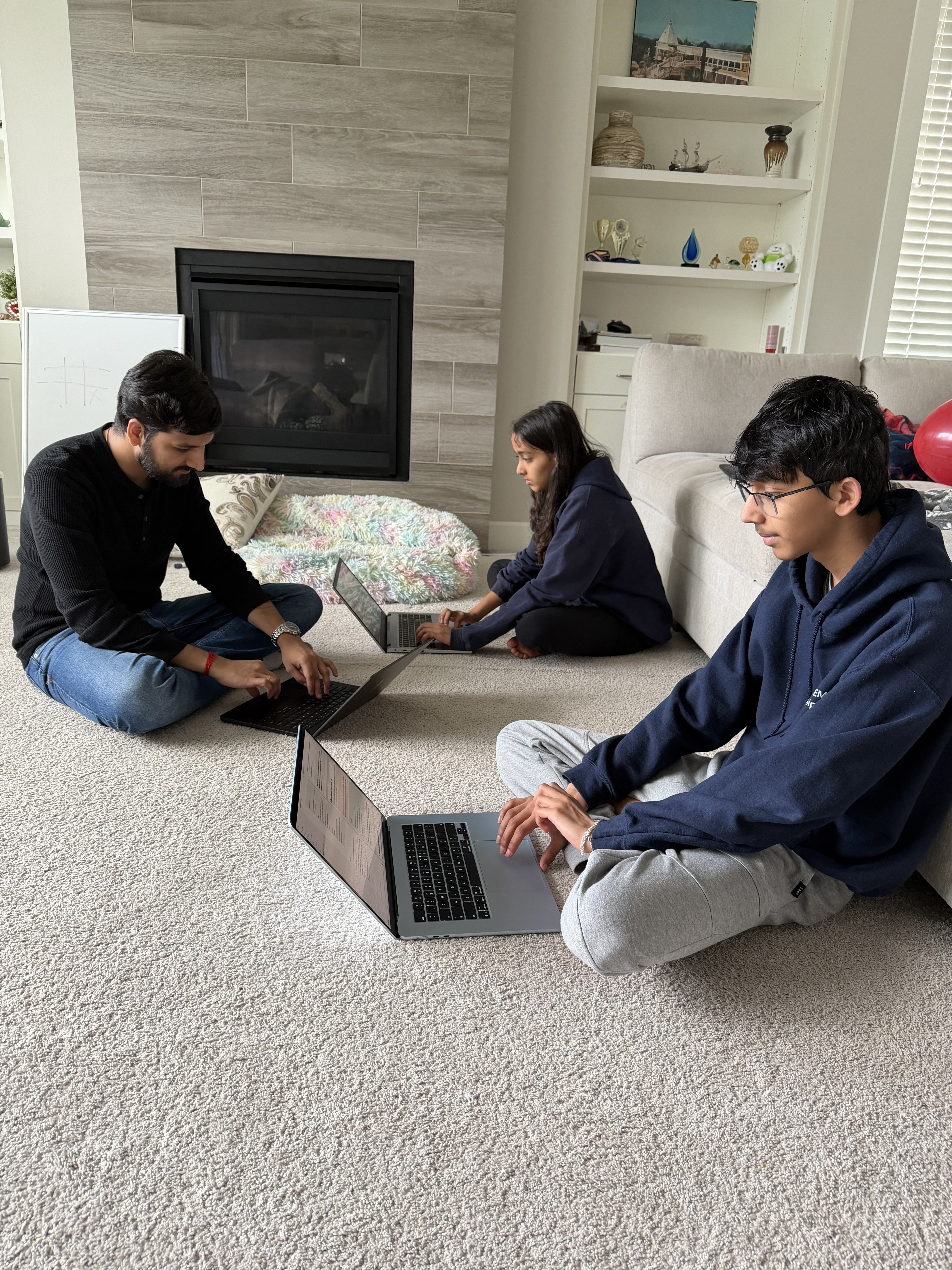 Three teens building AI tools with Gaurav at his kitchen table